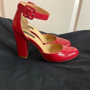 Red closed toe patent leather shoes. Size 8.5. Straps around ankles.